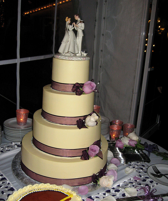 This is a round four tiered cake with a cream colored butter cream icing