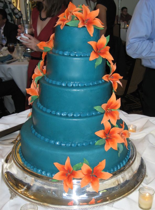 This is a five tier round cake covered in a deep teal 