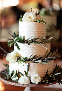white cake with greens and flowers
